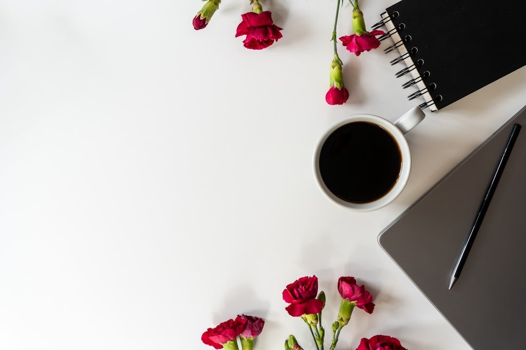 Flat lay of a notebook, pen and coffee cup on a desk