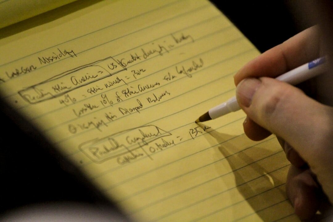 person writing in notebook